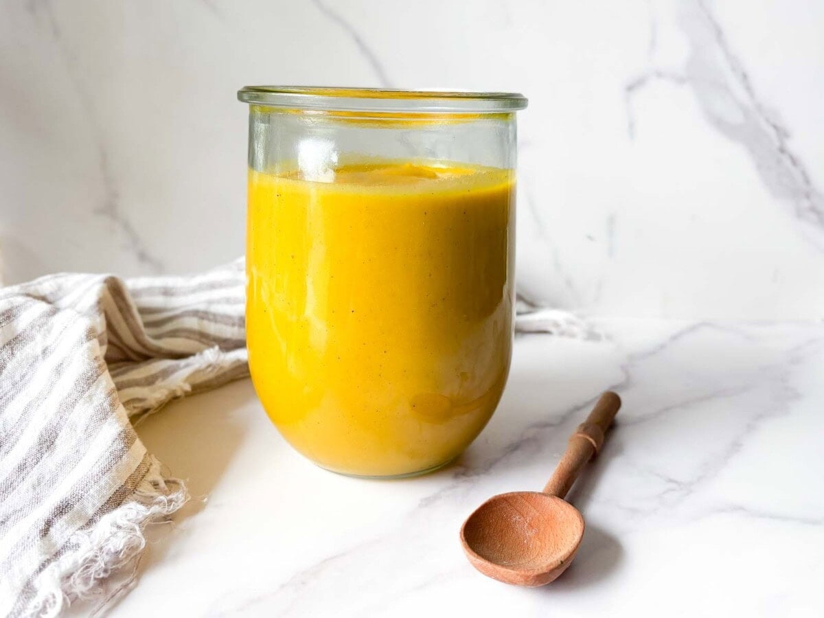 jar of butternut sauce next to wood spoon.