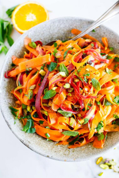This Moroccan carrot salad is a light and refreshing side dish. Made with fresh carrots, herbs, pistachio nuts, dates, and an orange-cumin dressing. Vegan.