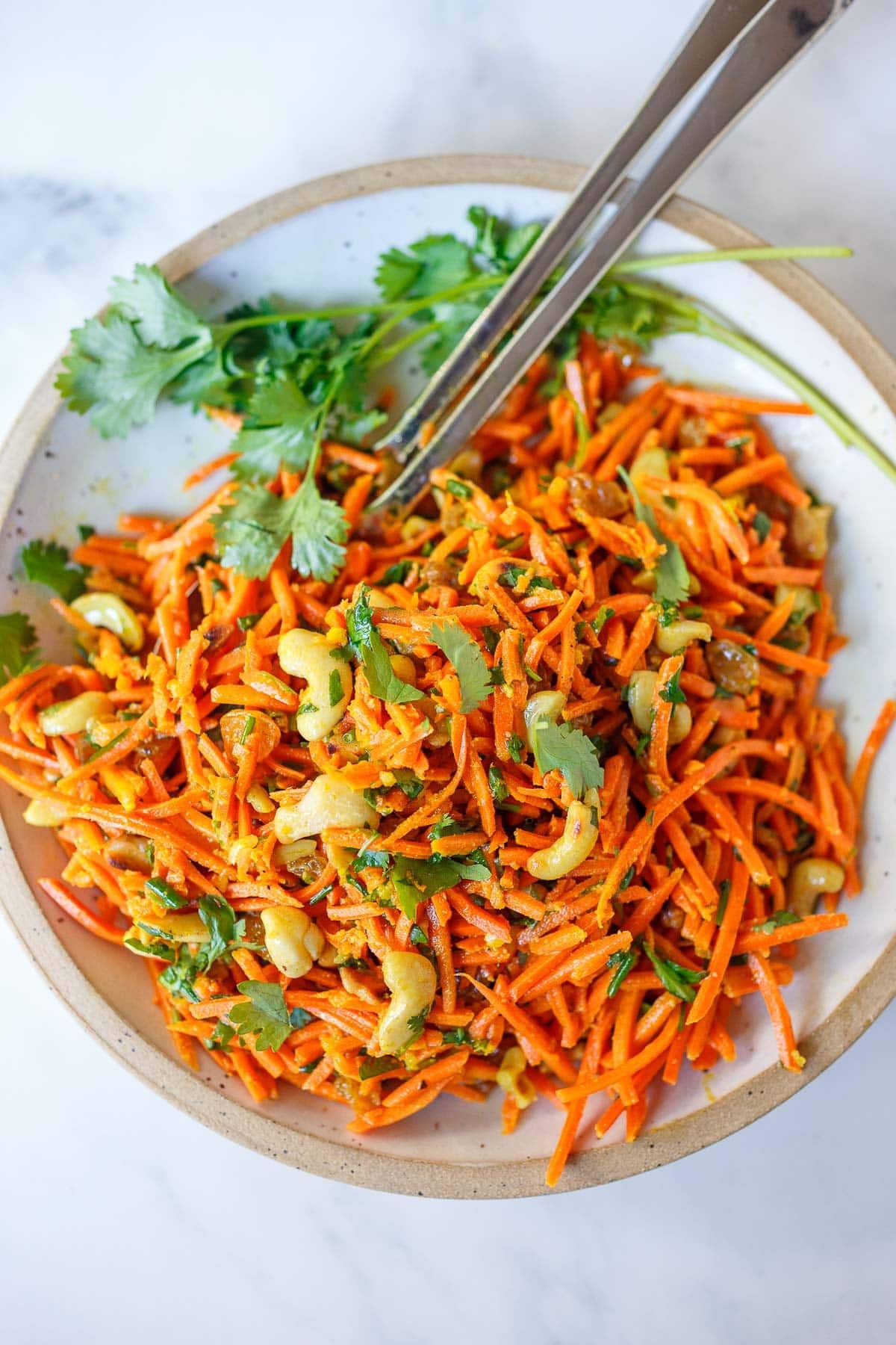 Fresh and flavorful, this carrot salad recipe is infused with Indian flavor! Studded with toasted cashews and raisins, fresh grated carrots are tossed in a delicious Indian curry dressing. Easy, healthy, vegan, and perfect for gatherings!