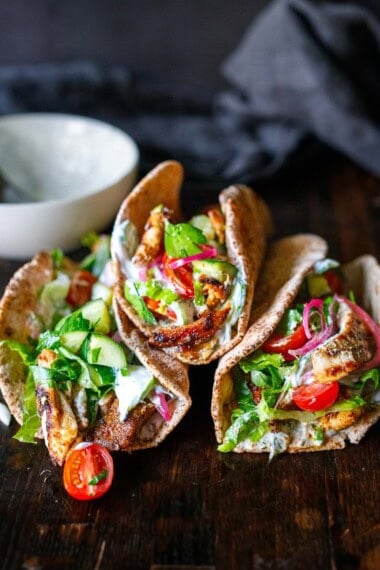 This easy Gyro recipe is made with chicken and packed with authentic Greek flavor! Tender succulent chicken is marinated, then cooked to perfection. Tuck it into warm pita bread with tzatziki, tomatoes, cucumbers, and onions. Vegetarian-adaptable!