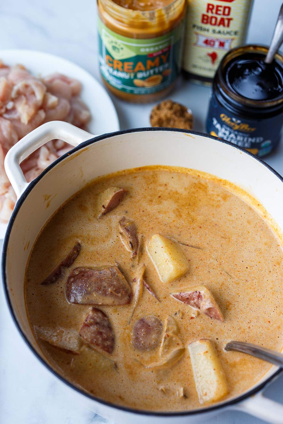 pot with thai massaman curry with coconut milk, peanut butter, and potatoes added.