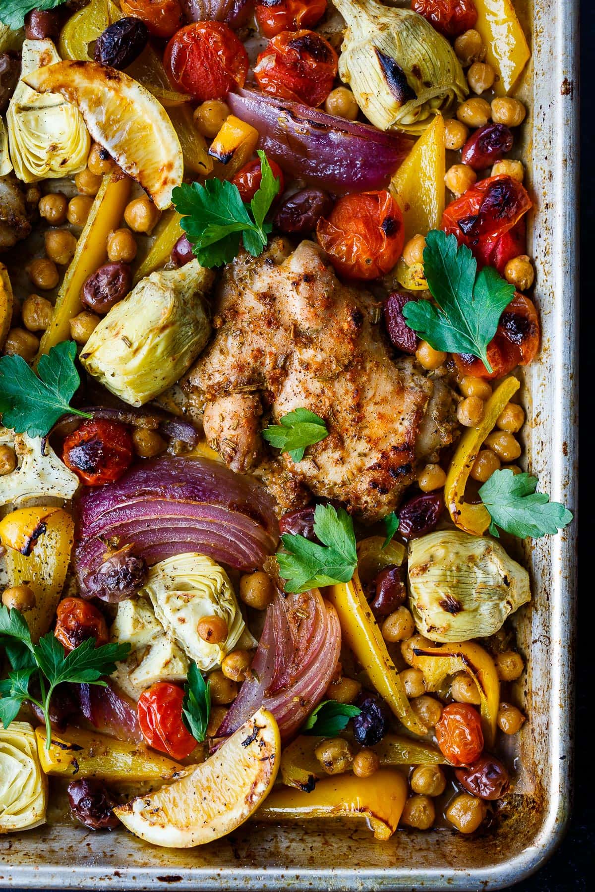 Mediterranean Chicken with veggies, chickpeas, olives and herbs. A delicious Sheet Pan Dinner.