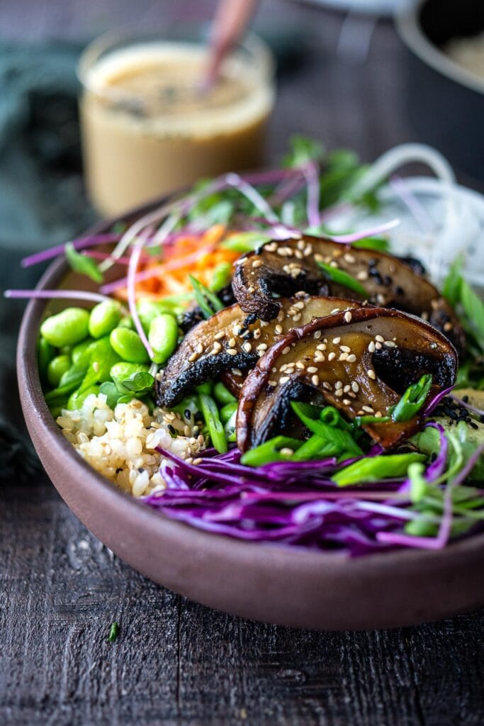 miso mushroom bowl with rice, edamame, purple cabbage, scallions, carrots, and micro greens.