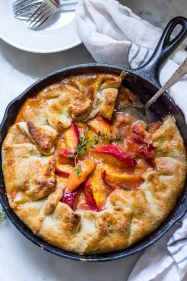 This farm-style Peach Pie recipe is baked in a cast-iron skillet and made with fresh summer peaches, featuring a golden, flaky crust. It's an irresistible dessert that comes out perfect every time!