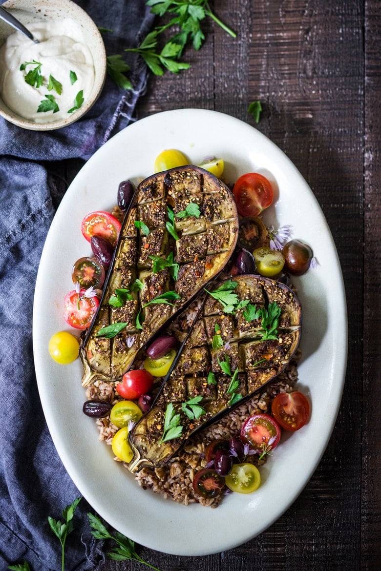 Crosshatched Zataar Roasted Eggplant served over rice with fresh parsley, cherry tomatoes, and kalamata olives. 