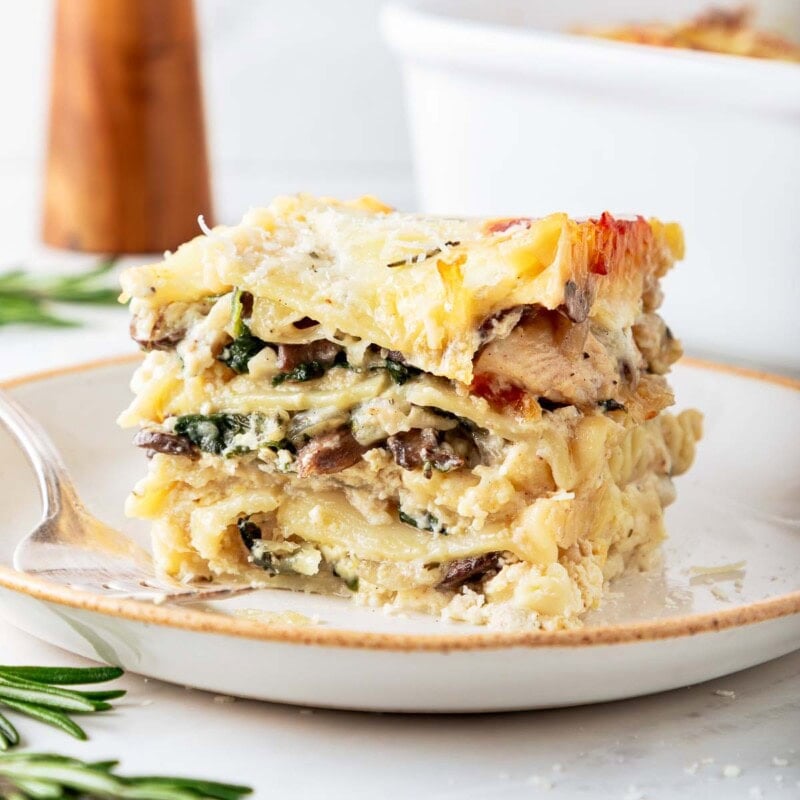 A delicious, cozy recipe for Rosemary Chicken Lasagna with mushrooms and spinach in a creamy Béchamel Sauce. A hearty meal perfect for special gatherings or Sunday supper. Vegetarian-adaptable. Video!