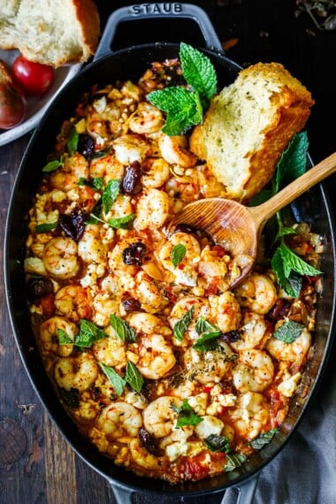 shrimp saganaki with feta and mint in a 2 handled skillet.