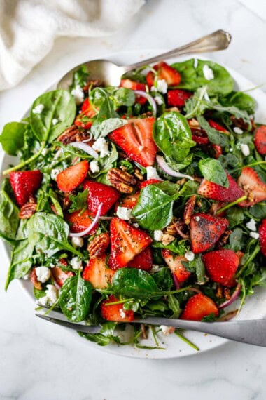 This strawberry spinach salad with vanilla-balsamic poppy seed dressing, pecan brittle, basil, and goat cheese is a delicious, healthy crowd pleaser! 
