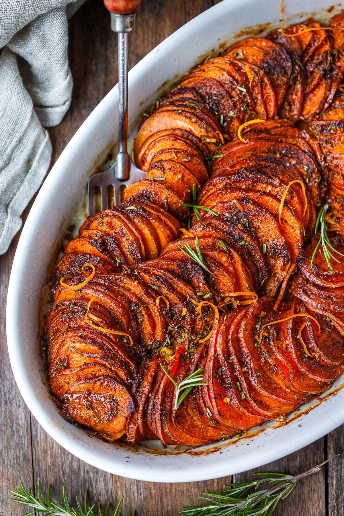 serving dish with vegan sweet potato casserole with orange zest and rosemary.